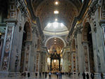 Looking up the nave of St. Peter's.  Michelangelo, who was not the original architect, designed a church that would have a the shape of a Greek cross - one in which all the branches are equal.  After Michelangelo died, the plan was modified to a Roman cross - like the cross above western altars.  The window at the end of the apse is two football fields away.  The canopy over the altar is seven stories high.  The statues sunk in the pillars along the sides are 15 (bottom statue) to 21 (top) feet tall.    