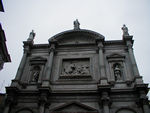 The top of the facade of San Rocco.  Saint Rocco spent his life caring for plague sufferers.  (If the picture were better, you could see bodies being carried off in the relief.)  When he returned home, he was so thin and looked so terrible that nobody recognized him. Instead they tossed him in the slammer.  Only his faithful dog kept him company.  That's why he is often represented with a small dog.  In 1485, his body was moved to Venice, and he became one of the protectors of the city.  (No word on whether he likes that job or not.)