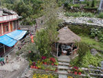 The main "road" is on the left.  It runs past the green awnings.  The little hut is part of the guesthouse.  The "road" is a path, sometimes stone, sometimes dirt, and sometimes mule .  . . well, you can guess.