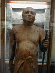 Sheikh el Balad.  The workmen who dug up this statue named this statue after their village headman, because they thought there was a resemblance.  It's really of Ka-aper, a chief lector priest in charge of reciting prayers for the dead in temples and chapels.  The eyes are inlaid: their rims are copper; whites, opaque quartz; and cornea, transparent crystal.  The pupil was made by drilling a hole in the back of the cornea and filling it with black paste.