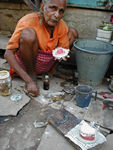 Sidewalk denture manufacturer with his wares.