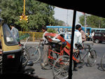 Street scene of rickshaw and the front of an autorickshaw.  We often use auto rickshaws - three wheelers steered with handlebars.  They are open on the sides, so the heat, noise, and exhaust rides along with us.  Whenever we get going very fast, I start getting nervous.  Fortunately, there's rarely a chance to go very fast.